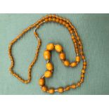 A GRADUATED STRING OF OVAL AMBER BEADS. LARGEST BEAD 18.8mm, SMALLEST BEAD 7.2cms. LENGTH 120cms.