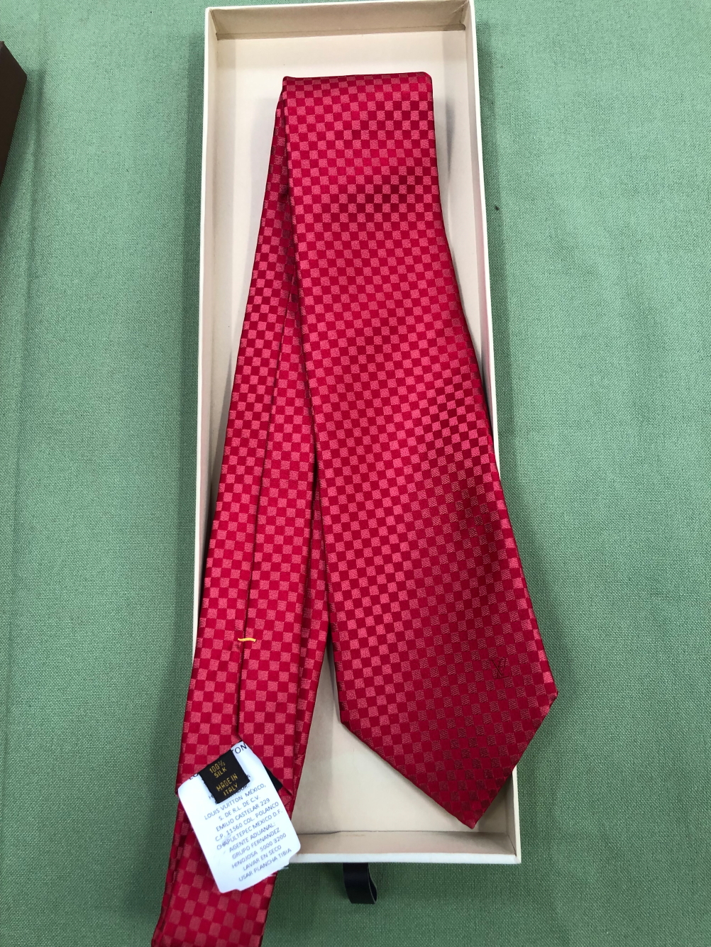 A LOUIS VUITTON RED SILK TIE.