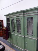 A GREEN PAINTED BREAKFRONT BOOKCASE WITH GREY DETAILS, THE UPPER HALF GLAZED AND THE BASE WITH