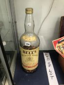 A BELLS 4.5 LITRE WHISKY BOTTLE HALD FILLED WITH COINS.