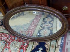 AN OVAL MIRROR IN A FAUX BOIS FRAME. 81 x 55cms.