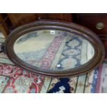 AN OVAL MIRROR IN A FAUX BOIS FRAME. 81 x 55cms.