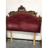 A MAHOGANY DOUBLE BED HEAD CARVED WITH ROCAILLE AND SCROLLING LEAVES ABOUT BUTTONED PURPLE VELVET. W