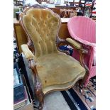 A VICTORIAN WALNUT SHOW FRAME ARMCHAIR BUTTON UPHOLSTERED IN HONEY COLURED VELVET AND CARVED WITH