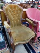 A VICTORIAN WALNUT SHOW FRAME ARMCHAIR BUTTON UPHOLSTERED IN HONEY COLURED VELVET AND CARVED WITH