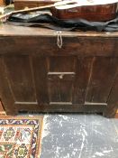 A LARGE OAK TRUNK OR COFFER, THE HINGED LID OVER AN INTERIOR HELD BY A CENTRAL IRON BAR. W 120 x D
