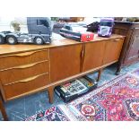 A 20th C. RETRO TEAK SIDE BOARD, THE CENTRAL DRAWER FLANKED ON ONE SIDE BY THREE DRAWERS AND ON THE