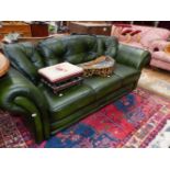 A GREEN LEATHERETTE UPHOLSTERED THREE SEAT SETTEE