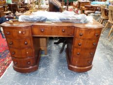 A 20th C. MAHOGANY PEDESTAL DESK THE KNEEHOLE DRAWER FLANKED BY BANKS OF FOUR BOW FRONTED DRAWERS ON