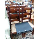 A SET OF FOUR 20th C. OAK LADDER BACK CHAIRS WITH RUSH SEATS ABOVE SQUARE SECTIONED LEGS