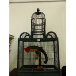 A KHAKI PAINTED WOOD AND WIRE BIRD CAGE HOUSING A WOODEN PARROT