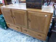 AN ERCOL ELM SIDEBOARD WITH THREE DOORS ABOVE TWO DRAWERS. W 129 x D 43 x H 75cms.