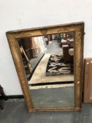 A RECTANGULAR MIRROR IN A 19th C. GILT FRAME, THE CAVETTO WITH ANTHEMION CORNERS AND CENTRAL