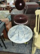 A 1950S CIRCULAR COFFEE TABLE, THE FORMICA TOP DECORATED WITH MUSICAL INSTRUMENTS TOGETHER WITH A