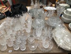 A LARGE COLLECTION OF CUT GLASS TO INCLUDE DRINKING GLASSES, ROSE BOWLS, FRUIT BOWLS, VASES ETC.