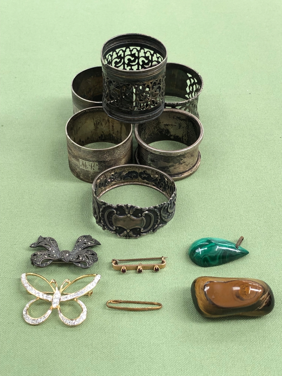 SIX ASSORTED HALLMARKED SILVER NAPKIN RINGS, TOGETHER WITH A GOLD AND GARNET BAR BROOCH, THREE OTHER