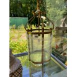 AN BRASS AND CURVED GLASS HANGING HALL LANTERN