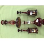 A BOHEMIAN RUBY GLASS DECANTER WITH OTHERS AND A CANDLESTICK.