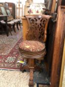 AN UNUSUAL CARVED VICTORIAN REVOLVING HIGH BACKED CHAIR