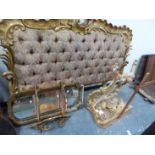 A BUTTON BACK UPHOLSTERED DOUBLE BED HEAD FRAMED BY GILT ROCAILLE, A GILT WOOD CONSOLE TABLE