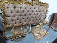 A BUTTON BACK UPHOLSTERED DOUBLE BED HEAD FRAMED BY GILT ROCAILLE, A GILT WOOD CONSOLE TABLE