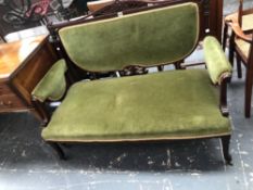 AN EDWARDIAN MAHOGANY SHOW FRAME TWO SEAT SETTEE UPHOLSTERED IN GREEN VELVET