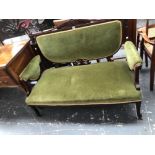 AN EDWARDIAN MAHOGANY SHOW FRAME TWO SEAT SETTEE UPHOLSTERED IN GREEN VELVET