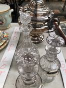 THREE GLASS DECANTERS, TWO WITH HALLMARKED SILVER LABELS AND A LARGE SILVER PLATED TUREEN.