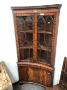 A 20th C. MAHOGANY CORNER CUPBOARD, THE INCURVED FRONT GLAZED ON THE UPPER HALF AND PANELLED ON