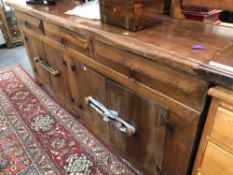 A LARGE CONTINENTAL RUSTIC OAK DRESSER BASE. H 92 W 220 D 46cms