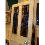 A VINTAGE PINE PANEL DOOR WITH INTERESTING INSET RELIEF ART GLASS PANES, H 196 x 77 cm's