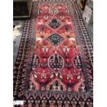 A PERSIAN TRIBAL RUG 308 x 132 cms