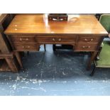 A 20th C. MAHOGANY TABLE WITH A CONFIGURATION OF FIVE DRAWERS, THE SQUARE LEGS TAPERING TO CERAMIC