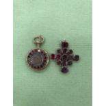 A 19th CENTURY FLAT CUT GARNET CROSS PENDANT AND A GILT METAL MEMORIAL LOCKET SET WITH GARNETS.