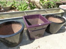 A PAIR OF BLACK AND ONE PURPLE GLAZED GARDEN PLANTERS