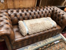 A BUTTON UPHOLSTERED BROWN CHESTERFIELD SETTEE. W 197cms.