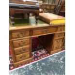 A 20th C. OAK PEDESTAL DESK, THE GREEN LEATHER INSET TOP OVER A KNEEHOLE DRAWER FLANKED BY BANKS