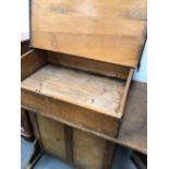 A LATE 19th/EARLY 20th C. OAK CLERKS DESK WITH A SLOPING LID OVER A COMPARTMENT AND A CUPBOARD TO