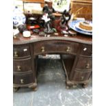 A 20th C. MAHOGANY KIDNEY SHAPED DESK, THE RIBBON AND FOLIAGE EDGED TOP OVER SEVEN DRAWERS AND