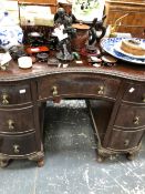 A 20th C. MAHOGANY KIDNEY SHAPED DESK, THE RIBBON AND FOLIAGE EDGED TOP OVER SEVEN DRAWERS AND