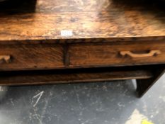 A 20th C. OAK SIDE TABLE WITH TWO APRON DRAWERS OVER AN OPEN SHELF SUPPORTED BY THE PLANK SIDES