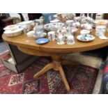 A LATE 20th C. OAK EXTENDING OVAL TABLE SUPPORTED ON A BALUSTER COLUMN AND FOUR LEGS. W 145 x D