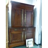 A 19th C. FRENCH OAK CABINET, THE DOORS OF THE UPPER HALF WITH FULL LENGTH BRASS FINGER PLATES,