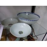A CHINESE BLUE AND WHITE RICE DECORATED BOWL TOGETHER WITH TWO FAMILLE ROSE BOWLS