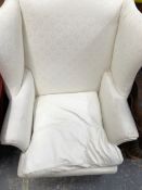 A MAHOGANY WING ARMCHAIR UPHOLSTERED IN WHITE WITH SQUARE SECTION FRONT LEGS