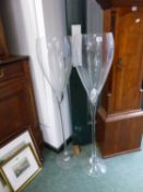 A PAIR OF OVERSIZED CHAMPAGNE FLUTE GLASSES.