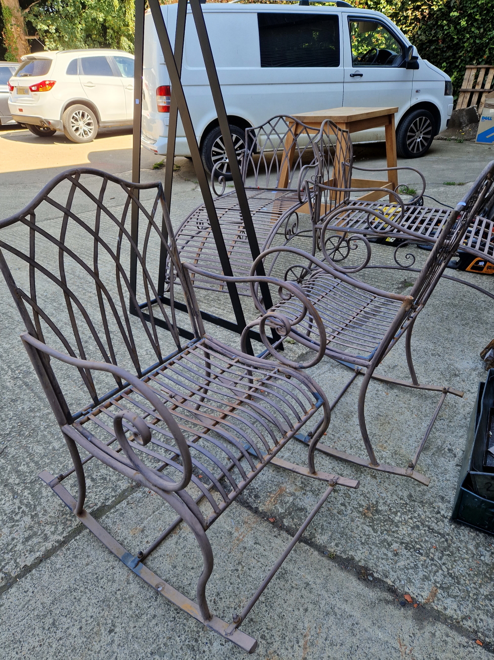 A FOUR PIECE PAINTED WROUGHT IRON PATIO SUITE CONSISTING OF TWO ROCKING ARM CHAIRS AND TWO SUN