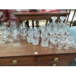 A PAIR OF CUT GLASS DECANTERS AND VARIOUS DRINKING GLASSES.