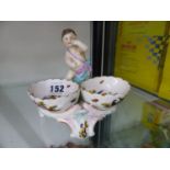 A BERLIN PORCELAIN DOUBLE SALT PAINTED WITH BIRDS AND SURMOUNTED BY A PUTTO