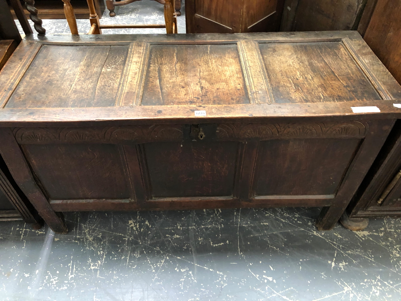 AN 18th C. OAK COFFER CARVED WITH A ROUND ARCH BAND ABOVE THE THREE PANELLED FRONT AND STILE LEGS. W
